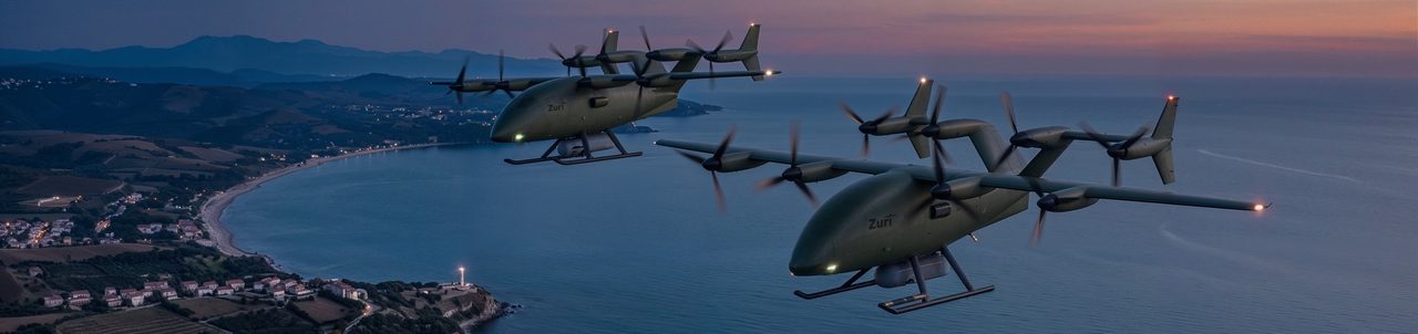Two uncrewed cargo aircraft in olive defense livery flying in formation along a coastline at dusk, a bay, a headland and a lit village below, a render