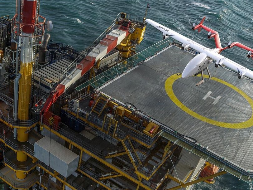 Zuri uncrewed cargo aircraft on the helideck of an offshore platform in open sea, a render