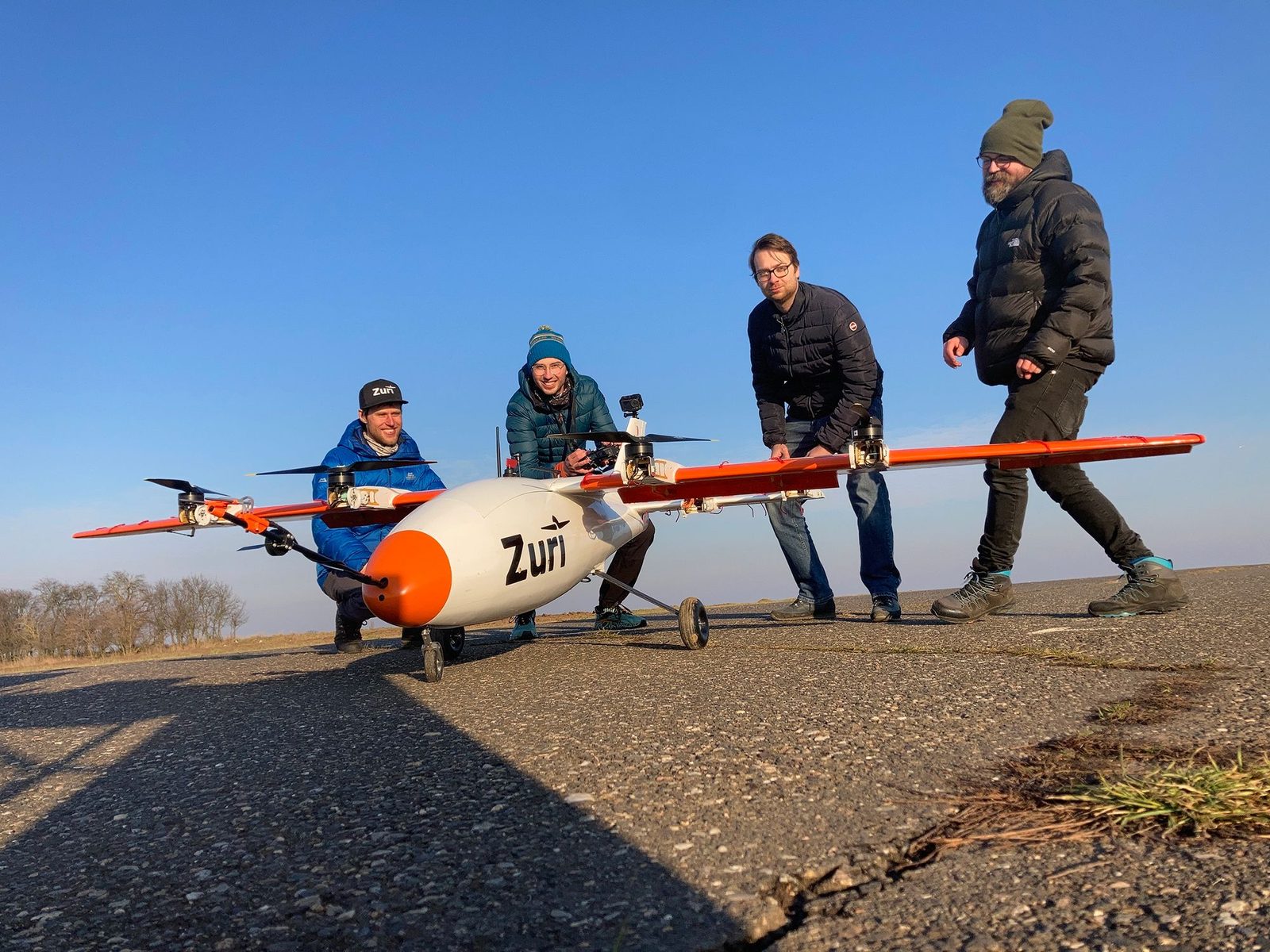 Team members wheeling a subscale test aircraft onto the runway