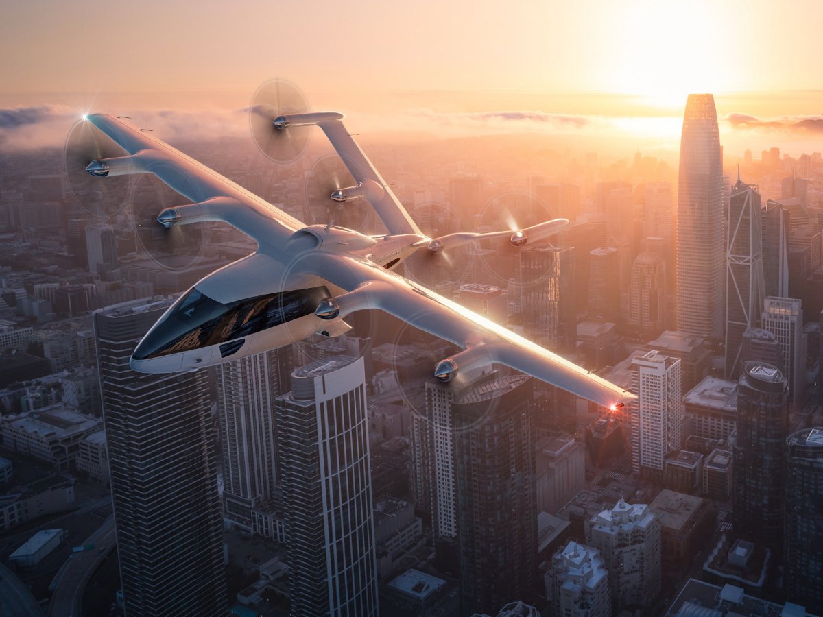 The six-seater in wing-borne cruise above a city at sunset, its cabin lit, a render