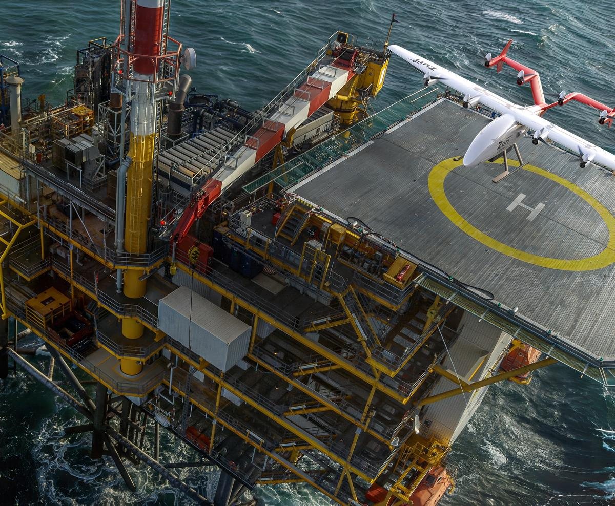 The Zuri uncrewed cargo aircraft on the helideck of an offshore platform, open sea beyond, a render