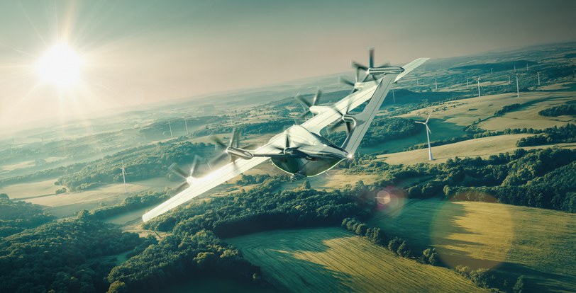 Render of the six-seat passenger aircraft banking above farmland and wind turbines, low sun behind it