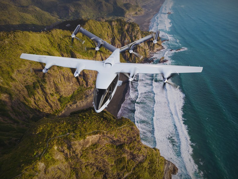 Render of the six-seat aircraft in cruise above a steep coastal cliff, surf breaking on the beach below