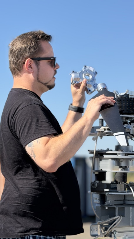 A Zuri engineer checking a propeller hub component by hand at the TD 2.0 test rig
