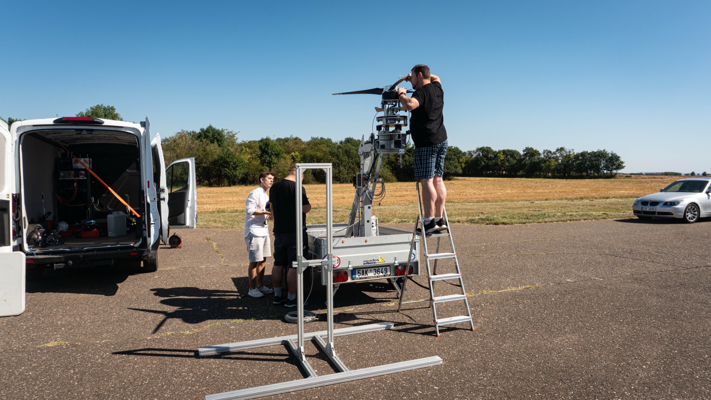 The TD 2.0 propeller test rig standing on the airfield beside the Zuri van, an engineer on a step ladder at the unit
