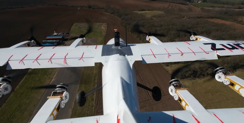 Overhead view of the Zuri V1NG demonstrator in flight, rows of red tufts across both wings showing airflow