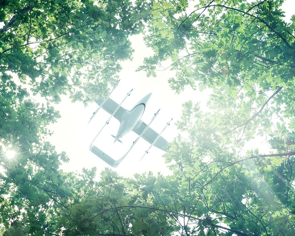 Zuri Hybrid VTOL flying above a green forest canopy, symbolizing sustainable innovation and growth after 2021 investment round with new angel investors, 