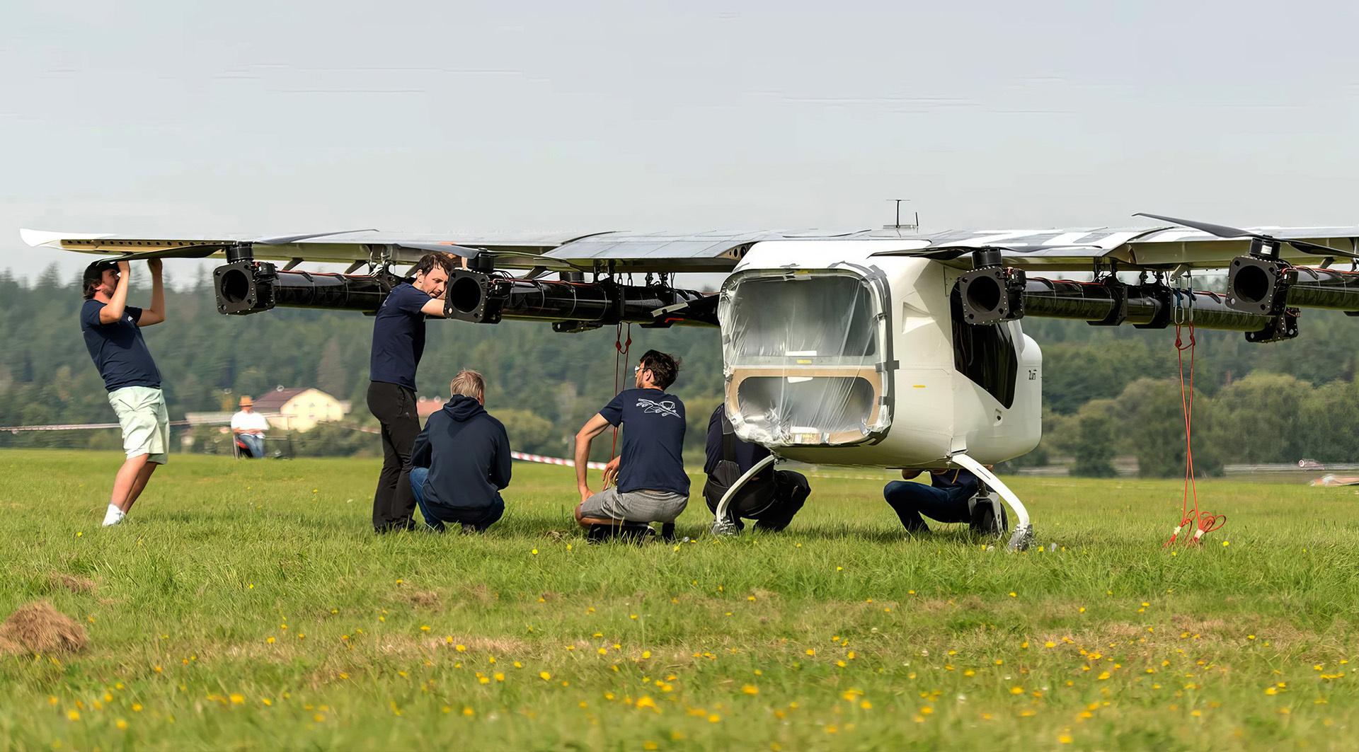 Zuri team preparing a full-scale hybrid VTOL aircraft in an open field for testing or demonstration.