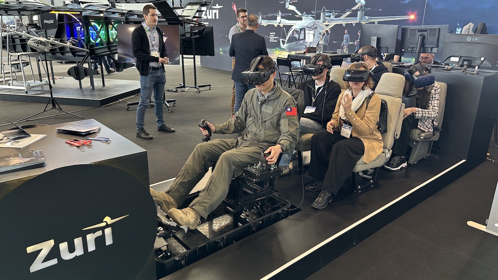 Visitors using Zuri's VR flight simulator at AERO Friedrichshafen 2025, experiencing hybrid VTOL from pilot and passenger perspectives.